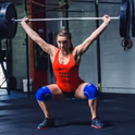 наколінники Rehband 7084 на спортсмені під час присідання зі штангою